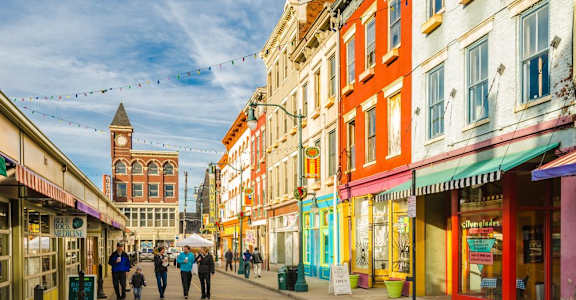 A street scene with people walking and colorful buildings.
