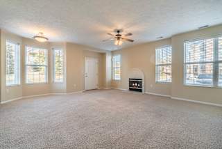 large open living room with tons of windows and a fireplace
