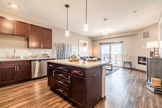 Kitchen island providing extra cabinet space and pendant lighting at 360 at Jordan West