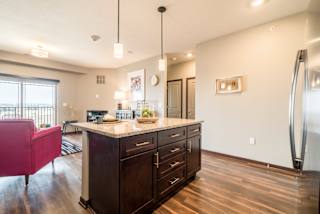 View of kitchen island and living room at 360 at Jordan West