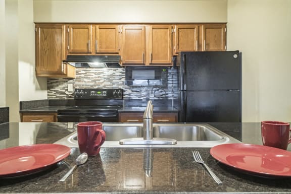 renovated kitchen with granite counters and new black appliances