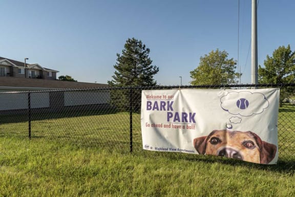 Fenced outdoor pet park labeled with signage reading