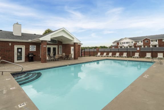 Swimming pool with lounge chairs outside of the clubhouse of Pine Lake Heights