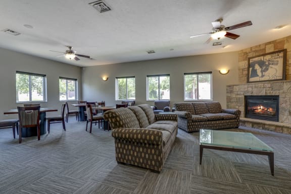 Sitting area with couches and chairs by fireplace in community clubhouse