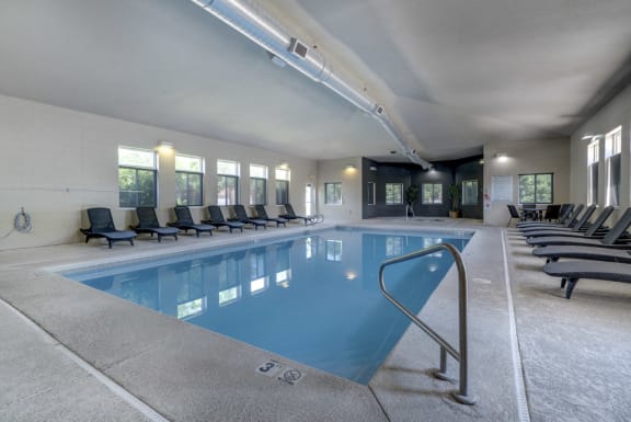 Indoor pool with lounge chairs at Pinebrook Apartments