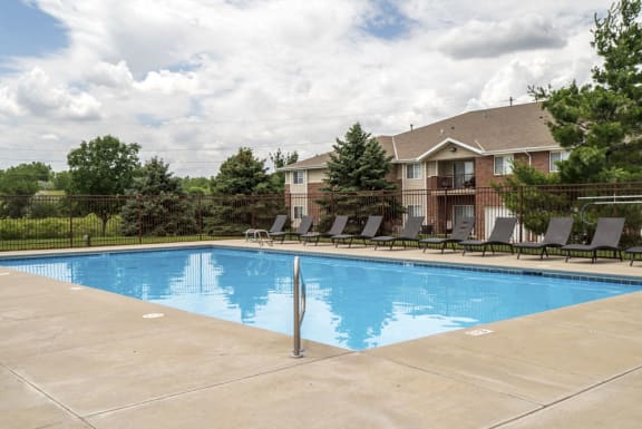 Large outdoor pool with lounge chairs at The Northbrook Apartments in Lincoln, NE