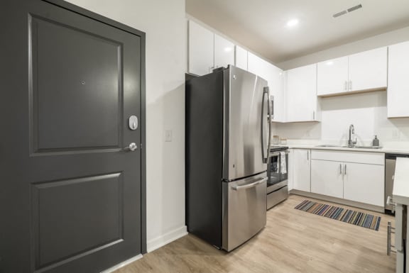 Inside of exterior door next to the kitchen with a full sized stainless steel fridge