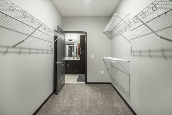 Walk in closet with wire shelves on each side for hanging and storing clothes