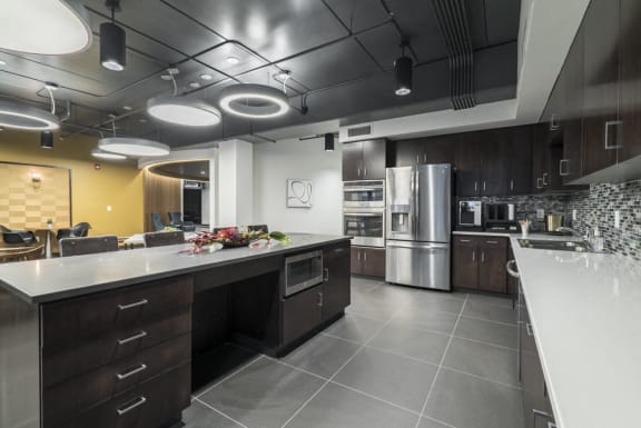 Large kitchen with island looking into the social area of the clubhouse at The Conrad