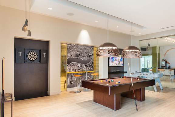 A room with a pool table and a dartboard on the wall. at Dock 79, District of Columbia