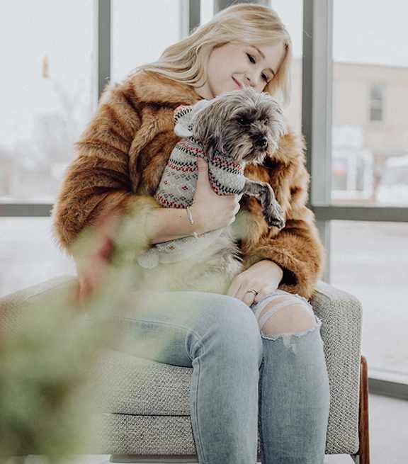 A bed with a white comforter and a tan blanket.