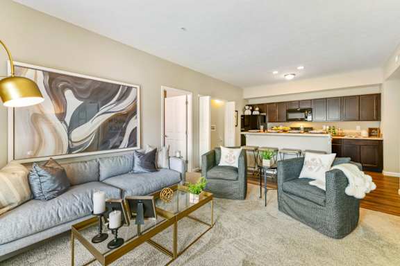 A modern living room with a grey sofa, two armchairs, and a coffee table.