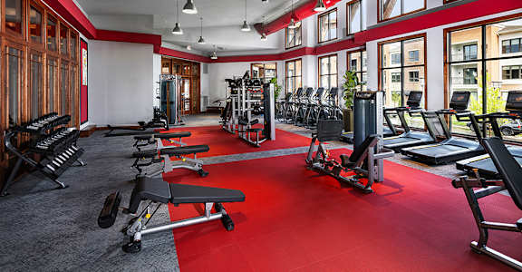 A gym with a red carpet and various exercise equipment.