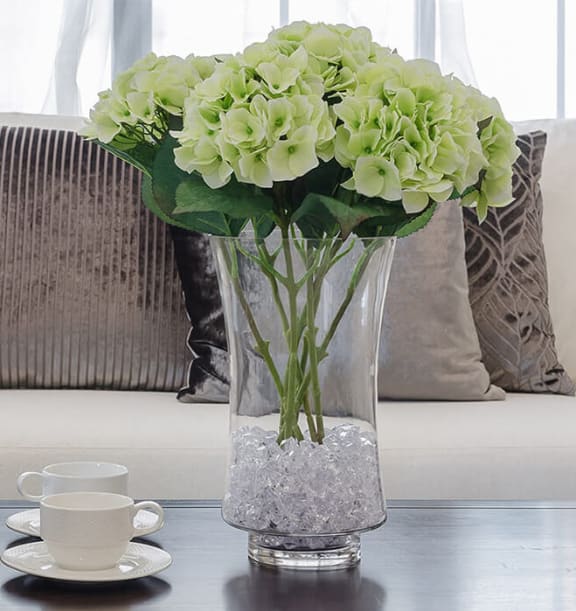Couch with a vase in front on a coffee table