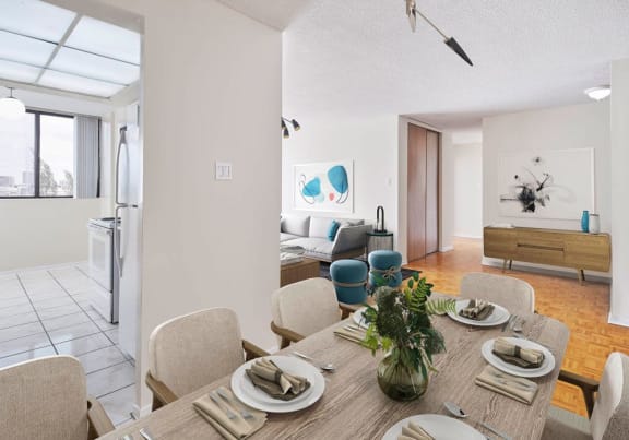 Open concept living and dining room staged with furniture. The kitchen is open from the dining room.