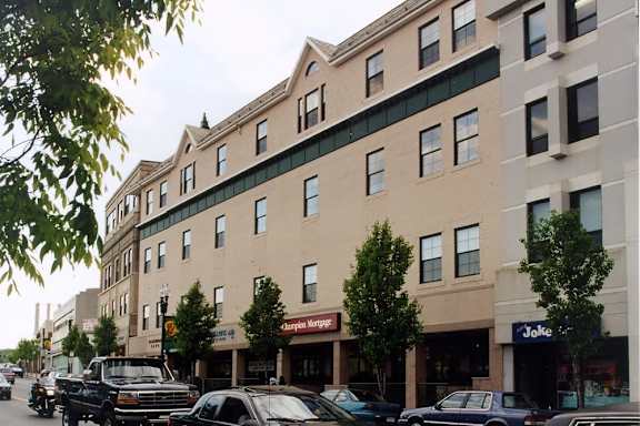 A row of cars parked in front of a building with a J.C. Penney storefront.
