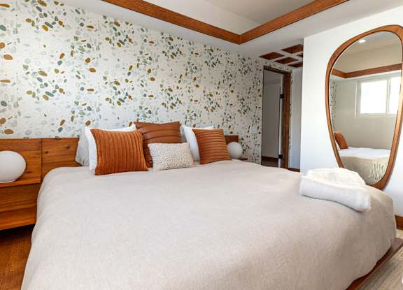 a bedroom with a large bed and a mirror at 8535 Colgate-Fully Furnished Apartments, Los Angeles