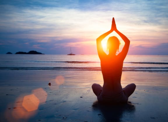 Woman Doing Yoga Pose on Beach at Sunset