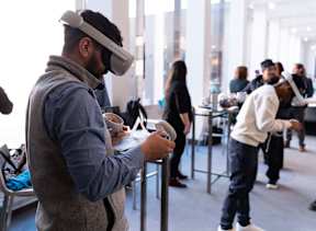 A man wearing a VR headset is playing a game on a Nintendo Switch.
