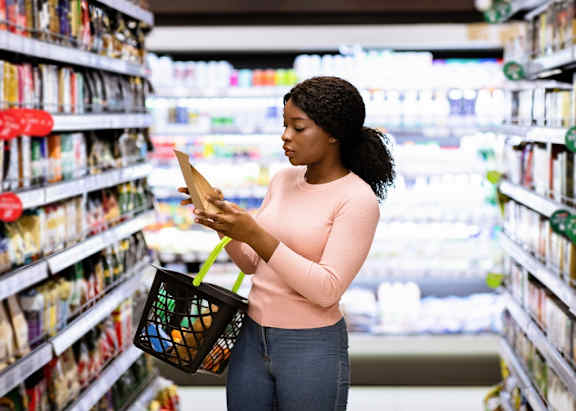 A woman is shopping in a grocery store aisle.