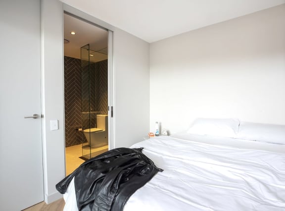 a bedroom with a white bed and a closet