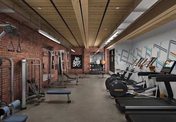 a gym with a brick wall and wood ceiling