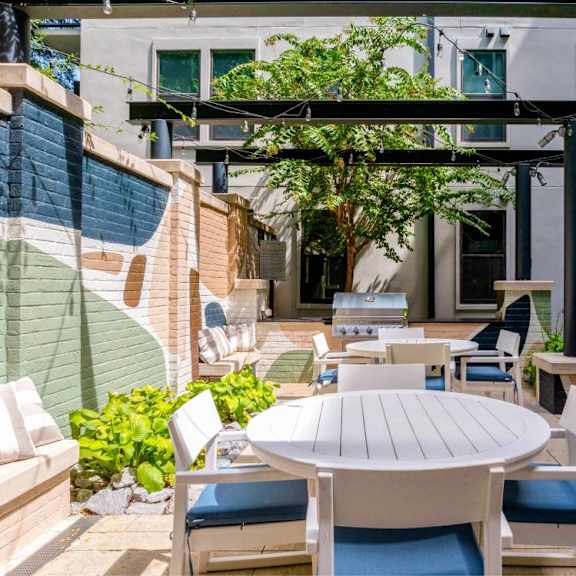 A patio with a table and chairs under a pergola.