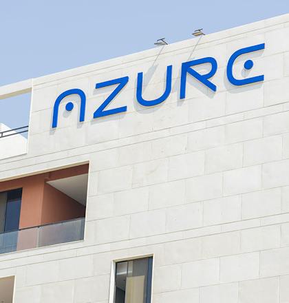 A white building with the letters "MZURC" on the side.