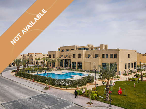 A large building with a pool in front of it.