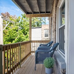 a porch with wicker chairs and a wooden deck