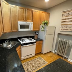a kitchen with black counter tops and wooden cabinets