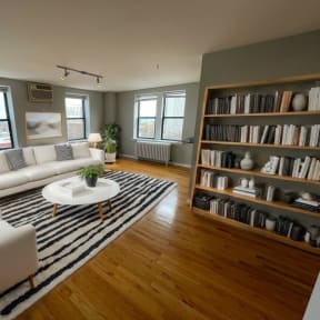 a living room with white furniture and a striped rug
