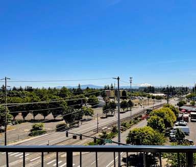 the view from a balcony of an empty parking lot and a city street
