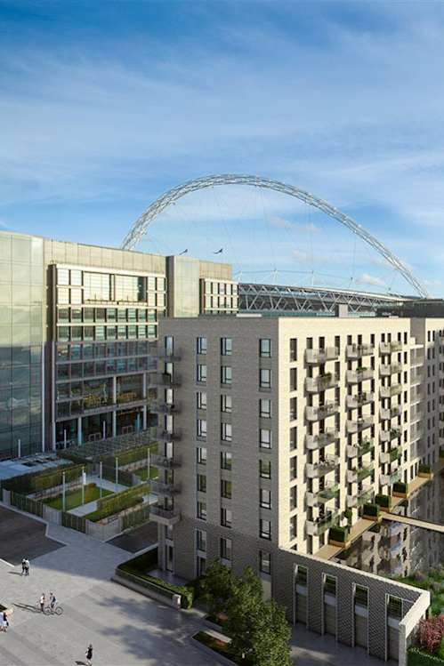 A modern building with a large arched structure in the background at Beton Apartments, Wembley, HA9 0SL