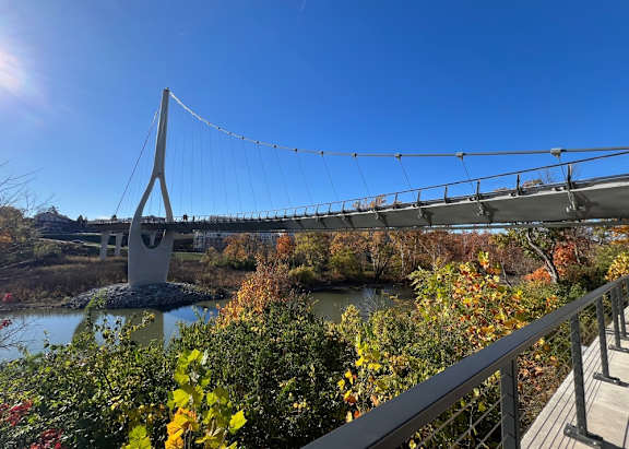 A bridge over a river surrounded by trees and foliage.