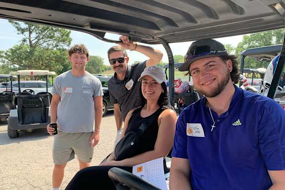 a group of people in a golf cart