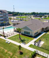 a large pond with a fountain in front of an apartment complex