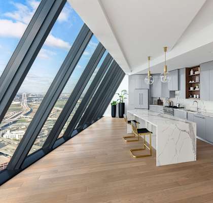 A modern kitchen with a view of the city through large windows.