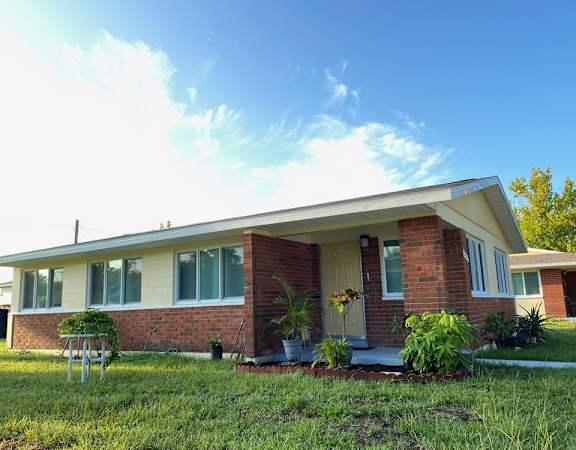 A house with a red brick exterior and a white roof.