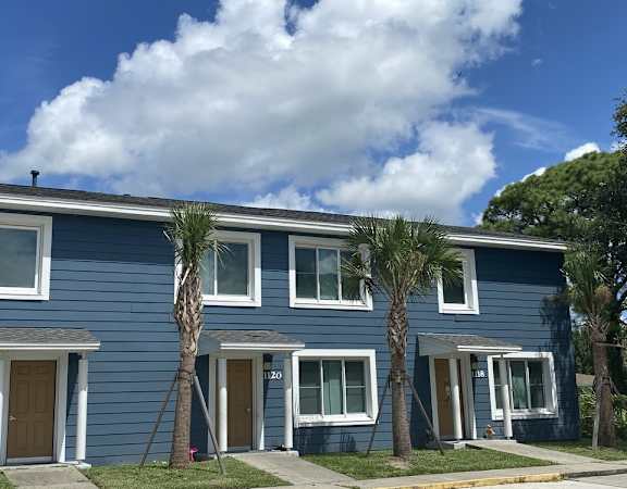 A blue house with a white door and windows.