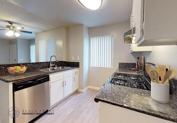 A kitchen with a black stove top oven and white cabinets.