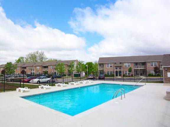 a swimming pool in front of canterbury house apartments