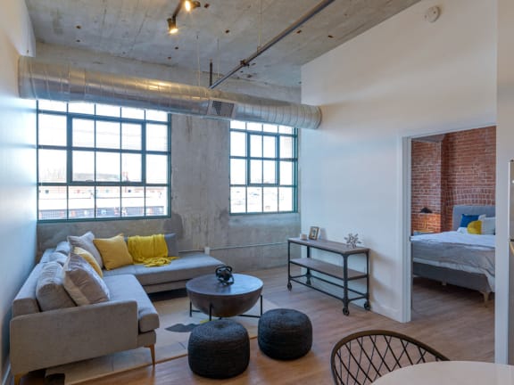 Living Room with Exposed Concrete Walls at Montgomery Mill Apartments in Windsor Locks, CT