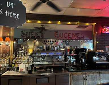 A bar with a neon sign that says "CREEK" on the wall.
