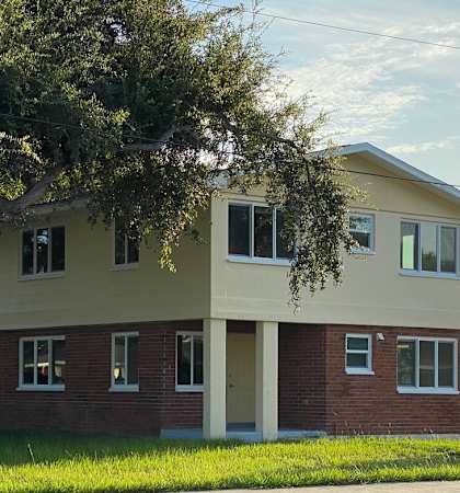 A two-story house with a red brick base and a beige upper level.