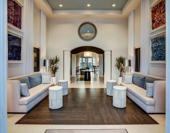 a long hallway with couches and tables in a hotel lobby