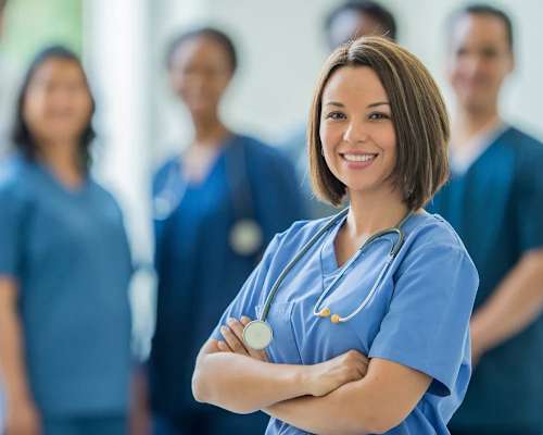 A group of medical professionals in blue scrubs stand in a line.