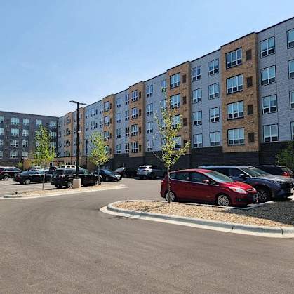 a parking lot with cars in front of a large building
