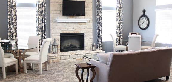 a living room with a fireplace and a table and chairs at Brookfield Village Apartments, Ohio, 43123