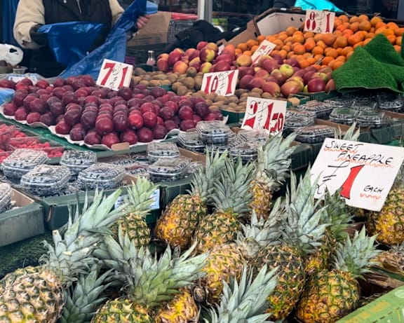 a display of pineapples and other fruits at a market